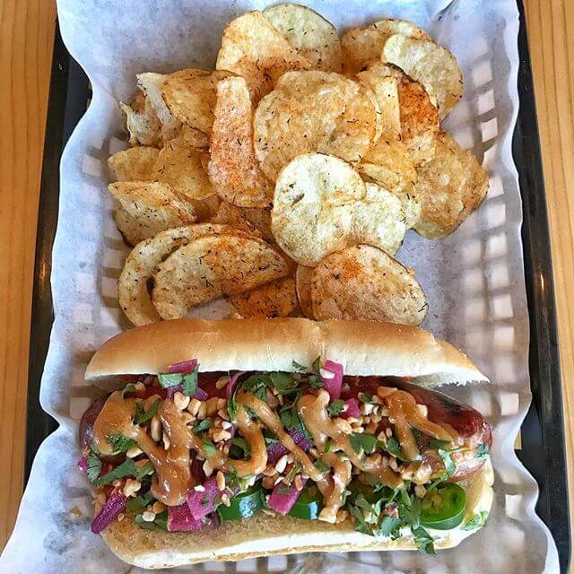 We just launched our #summer menu in the #pub and the food tastes amazing! Here is our Thai Peanut Dog that has peanut sauce, sriracha, pickled red onions, cilantro, peanuts, and jalapeños! We got all of our hotdogs from @ponofarmbend and they are amazing! We are open everyday in the pub from noon-10pm!